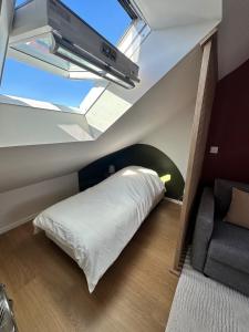 ein Schlafzimmer mit einem Bett, einem Fernseher und einer Couch in der Unterkunft Le precieux de la Gare in Saint-Pierre-des-Corps