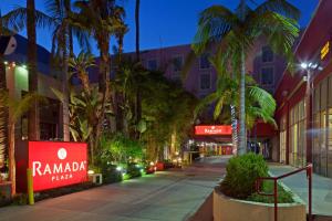 ロサンゼルスにあるラマダ プラザ ウェスト ハリウッド ホテル ＆ スイーツのヤシの木と建物の空き通り