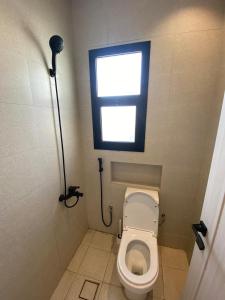 a small bathroom with a toilet with a window at Self-entry Studio in Jeddah