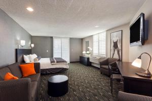 a hotel room with a bed and a couch at Ramada Plaza by Wyndham West Hollywood Hotel & Suites in Los Angeles