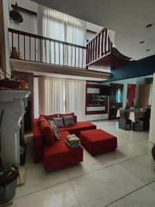 a living room with a red couch and a staircase at Luxury apartment - Fort Chambray in Għajnsielem