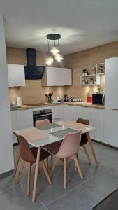 a kitchen with a table and chairs in it at LE SNOOKYBAY - Appartement Neuf - Classé 3 étoiles in Cavalaire-sur-Mer