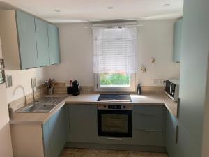 a kitchen with blue cabinets and a sink and a window at appartement en centre ville in Sainte-Maxime +3 photos