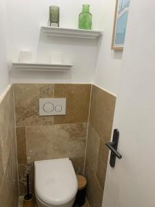 a bathroom with a toilet and shelves on the wall at appartement en centre ville in Sainte-Maxime