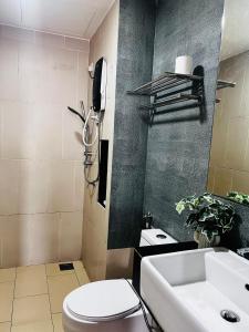 a bathroom with a toilet and a sink and a phone at Pool & Sea View Casa Azalea at Swiss Garden Resort Residence - 2 bedroom apartment in Kuantan