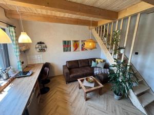 a living room with a couch and a staircase at Apartmán Stela in Spišské Tomášovce