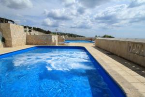 ein großer blauer Pool auf dem Dach eines Hauses in der Unterkunft Scogliera del Gabbiano in Santa Maria di Leuca