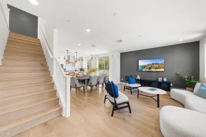 a living room with a staircase and a dining room at #Marbella Lane - Curated 5BR in Upscale RMV Haven in Ladera Ranch