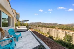a patio with blue chairs and a view of the desert at #Marbella Lane - Curated 5BR in Upscale RMV Haven in Ladera Ranch