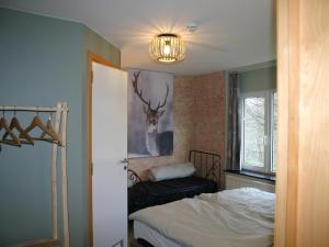 a bedroom with a bed and a picture of a deer on the wall at Home in Vielsalm with Sauna in Vielsalm
