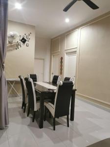 a dining room with a black table and chairs at Homestay Azkha in Langkawi Islands