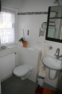 a white bathroom with a toilet and a sink at Ferienhaus Klein in Dresden