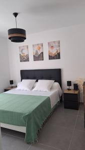 a bedroom with a large bed with a green blanket at LE SNOOKYBAY - Appartement Neuf - Classé 3 étoiles in Cavalaire-sur-Mer
