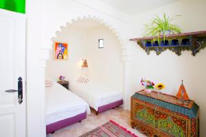 Kasbah Rose في طنجة: غرفة نوم بسريرين وطاولة مع ورد