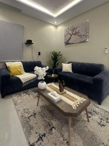 a living room with a blue couch and a table at New stay in Jeddah +1 photo