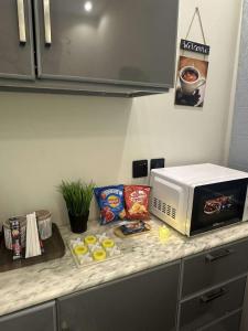 a counter with a microwave and some food on it at New stay in Jeddah