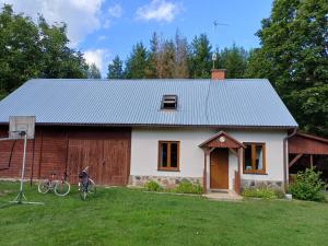 a small white house with a bicycle in the yard at Supieńska Przystań in Supienie +11 photos