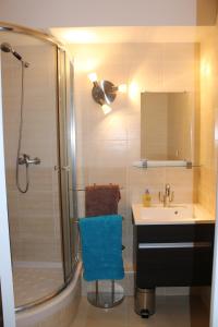 a bathroom with a shower and a sink with a blue chair at Studio Californie in Nice
