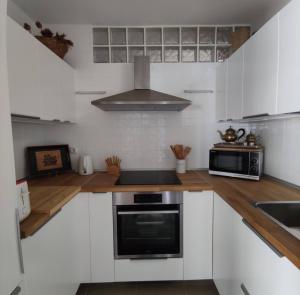 a kitchen with white cabinets and a stove top oven at Casa Vento in La Asomada +8 photos