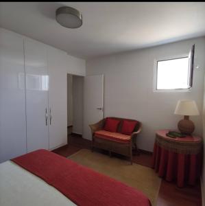 a bedroom with a bed and a chair and a window at Casa Vento in La Asomada