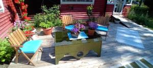 VäseStrandvikstugan的庭院配有椅子、桌子和鲜花