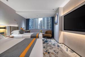 a hotel room with two beds and a flat screen tv at Golden Sea View Hotel Haikou in Haikou +289 photos
