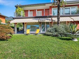 a house with two chairs in the yard at Sunny Villa with Terrace in Comerio