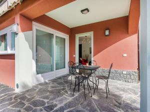 a patio with chairs and a table on a wall at Sunny Villa with Terrace in Comerio