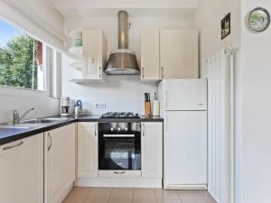a kitchen with white cabinets and a white refrigerator at Sunny Villa with Terrace in Comerio