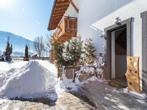 a house with snow on the ground next to a door at Apartment in Saalfelden near Ski Slopes in Saalfelden am Steinernen Meer