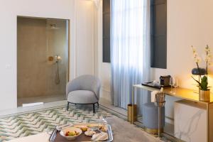 a room with a shower and a chair and a table at Palazzo Zimara - The D'Angelo Family Collection in Lecce