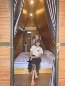a woman sitting on a bed in a tiny house at Biển Hồ Garden Glamping in Bien Ho +30 photos