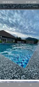 a picture of a swimming pool with blue tiles at Homestay Azkha in Langkawi Islands
