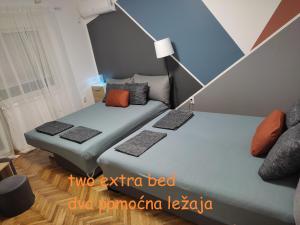 two twin beds in a room with ainylinylinylinylinylinylinylinyl at Ravena in Palić