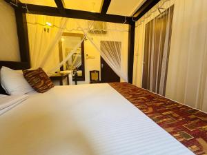 a bedroom with a large white bed with a window at Nooit Gedacht Holiday Resort Unawatuna in Unawatuna +49 photos