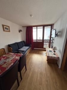 a living room with a couch and a table at Le Rond Point des Pistes in Tignes