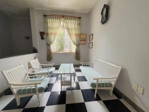 Zimmer mit Stühlen, einem Tisch und einem Fenster in der Unterkunft De Vong Riverside Homestay in Hoi An
