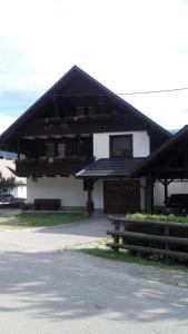 uma casa com um telhado preto e um alpendre em Apartment Cvetek Janez em Bohinj