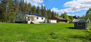 a house in the middle of a green field at Villa Davvi dállu in Vidsel