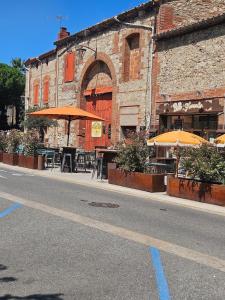 an empty street with tables and umbrellas in front of a building at Mediterranean Studio in Saint-Cyprien