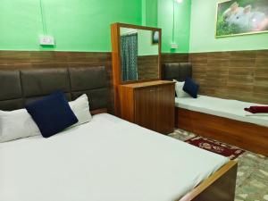 a room with two beds and a mirror at Hotel Raj in Siliguri
