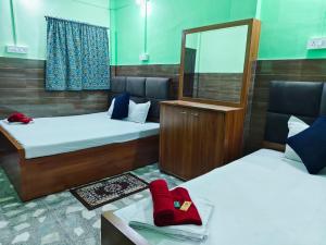 a room with two beds and a mirror at Hotel Raj in Siliguri +11 photos