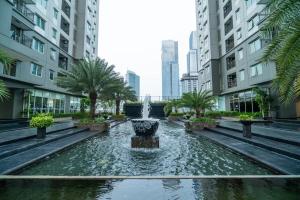 a fountain in the middle of a city with tall buildings at 1 BR Comfy & Premium Entire Apt By Deeta Living in Jakarta