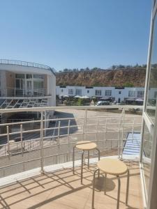 a balcony with two chairs and a building at Gold Bugaz in Odesa +4 photos
