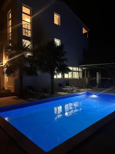 a swimming pool in front of a building at night at Vila Sunset in Kaštela