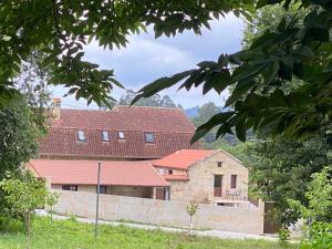 a house with red roofs and a stone wall at Casa Condesa in Pontevedra