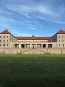 a large building with a grass field in front of it at Nyistandsat højloftet kælderlejlighed på 70 m2 i Viborg centrum, med plads til 4 personer in Viborg