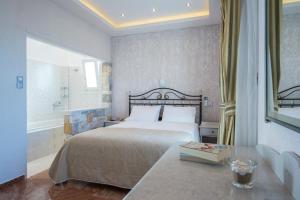 a bedroom with a bed and a table with a book at Contaratos Beach Hotel in Naousa