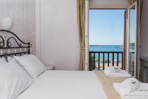 a bedroom with a bed with a view of the ocean at Contaratos Beach Hotel in Naousa