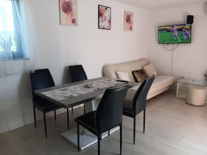 a dining room with a table and chairs and a couch at IGGY in Malinska